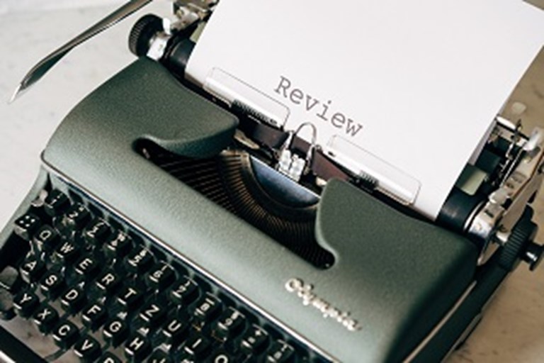 Typewrite with paper showing the words review